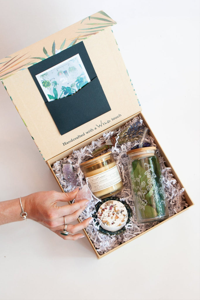 Gift box with candles and a book on a white surface