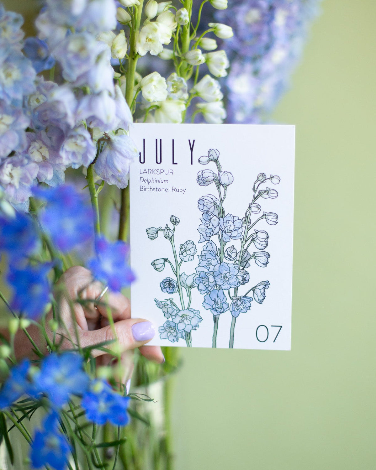 Calendar card for July with floral design and blue flowers in the foreground