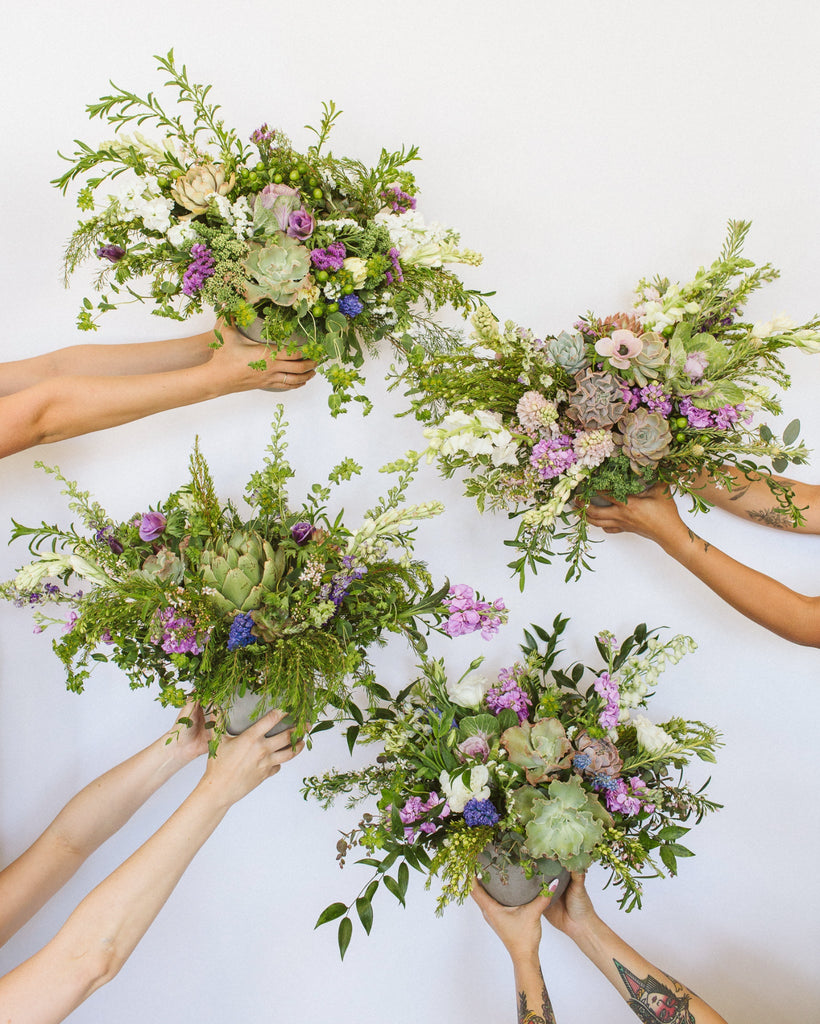 Multiple hands holding various floral bouquets against a white background