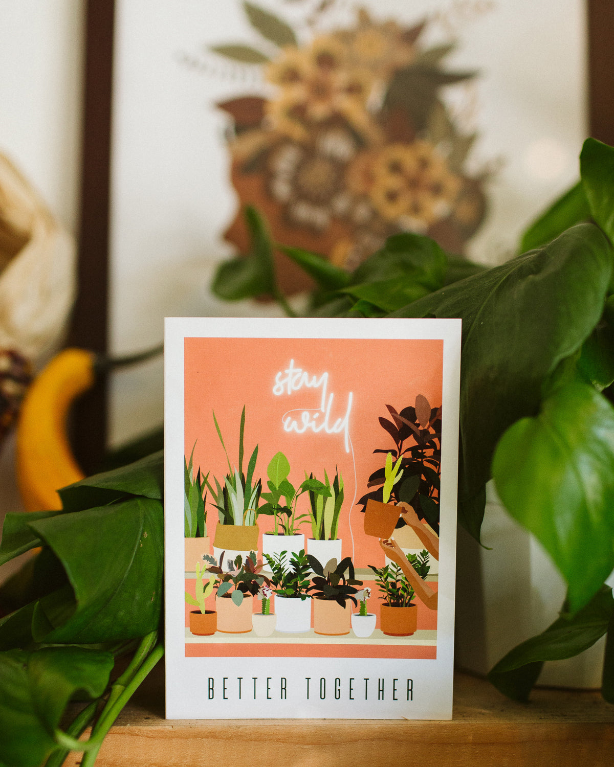 A greeting card that reads "better together". The artwork on it is of a shelf full of potted plants.