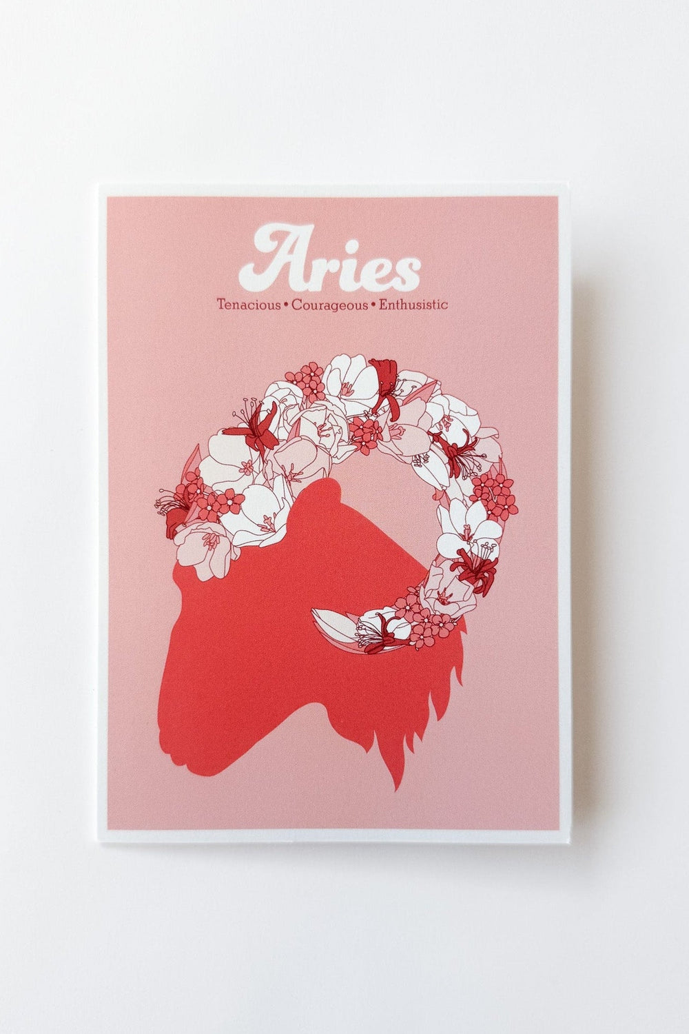 A greeting card featuring the Aries zodiac sign, with a red ram silhouette, white and red floral crown, and the word 'Aries' in white script on a muted red background, shown against a white background.