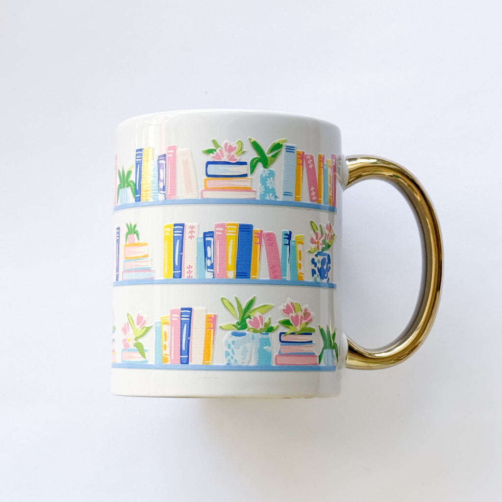 White mug with colorful book and plant pattern on a white background