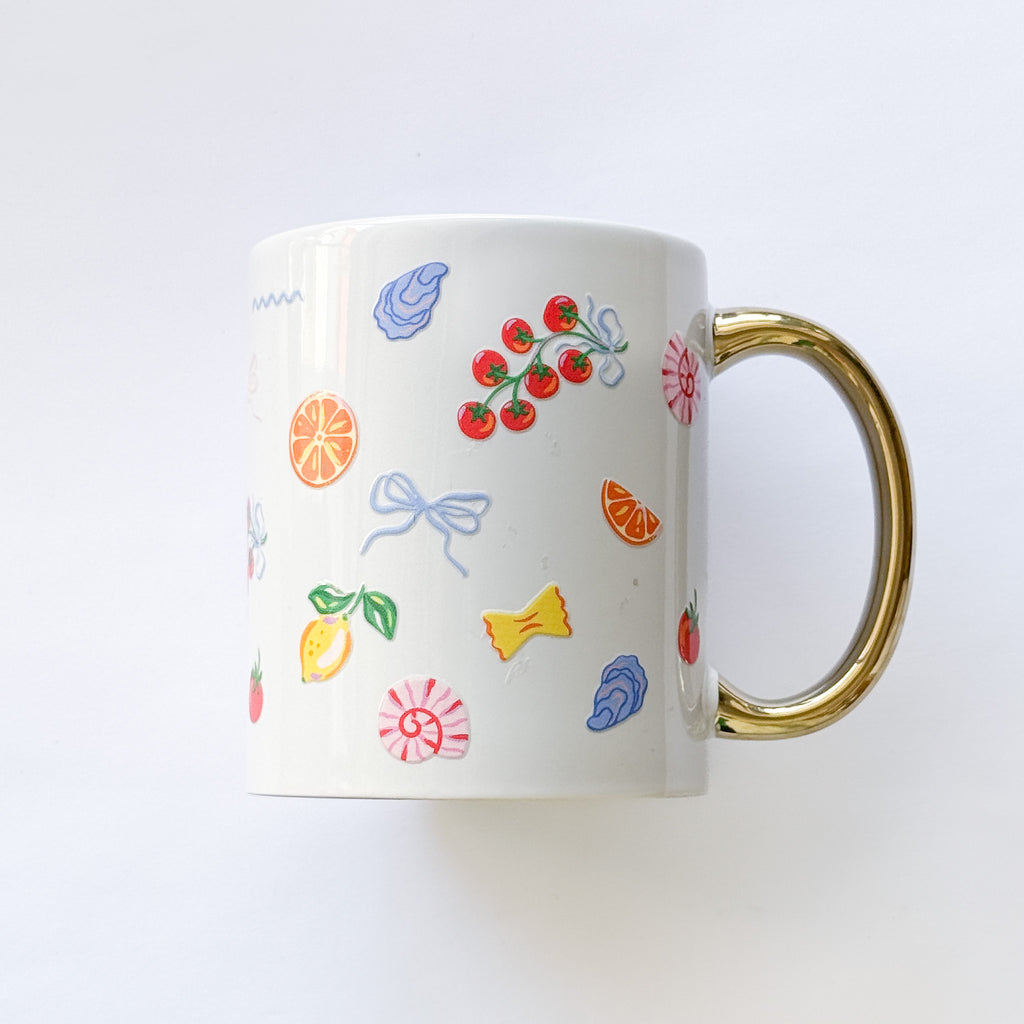 White mug with colorful fruit and bow designs on a white background