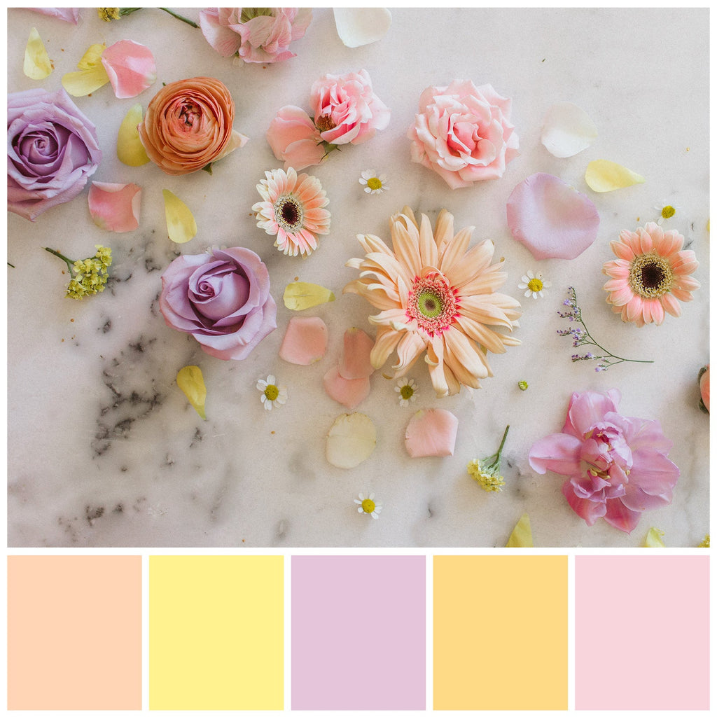 A color palette option: a flatlay of pastel-colored blooms on a marble background. The colors included are light shades of pink, peach, yellow, and purple.