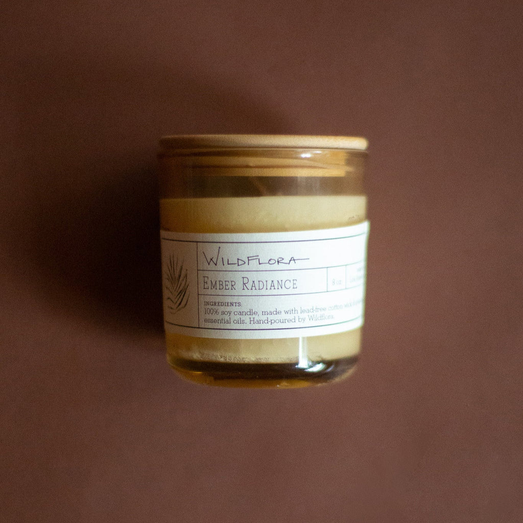 WildFlora Ember Radiance Candle with a label on a brown background