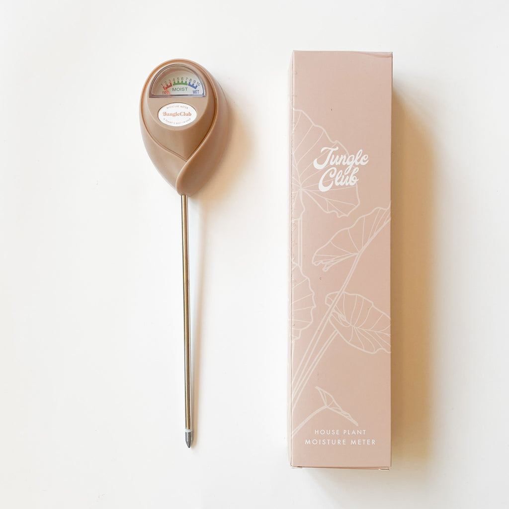 dusty rose colored plant moisture meter with similar-colored box, photographed on a clean white background.