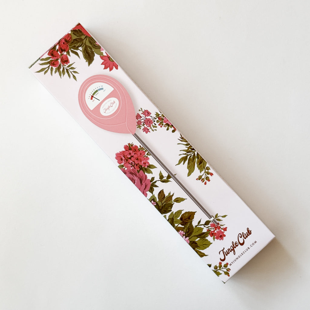 A pink plant moisture meter in its floral-patterned packaging, photographed on a clean white background.